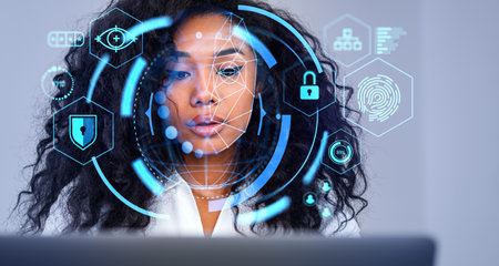 Beautiful serious young African American businesswoman using laptop with immersive facial...