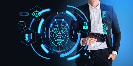 Unrecognizable businessman holding tablet computer with immersive biometric scanning interface over dark blue background. Concept of facial recognition and identificationの写真素材