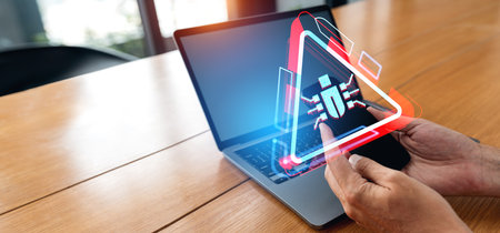 Businessman using laptop and smartphone in hands, mockup screen. Glowing red hologram with digital...