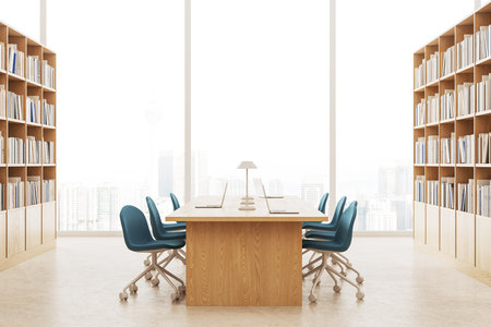 Stylish library interior armchairs and laptop on desk, wooden bookshelves on beige concrete floor. Reading and learning space with panoramic window on Kuala Lumpur. 3D renderingの写真素材