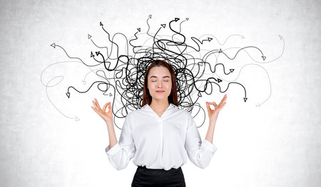 Businesswoman meditating with eyes closed, black arrows doodle on gray concrete wall background....