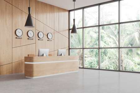 Interior of stylish office hall with wooden walls, concrete floor, white and wooden reception counter with clocks showing world time and panoramic window with tropical view. 3d renderingの写真素材