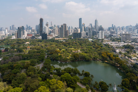 Lumpini Park in the morning, recreational area. Bangkok panoramic city view on financial center, skyscrapers, towers and park. Asian business city skylineの写真素材