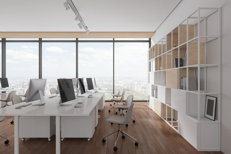 Cozy open space office interior with armchairs and pc computers in row, shelf with decoration on...