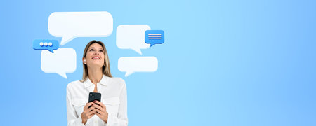 Smiling young woman with mock up empty chat bubble, wearing earbuds. Copy space blue background....