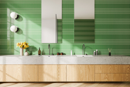 Interior of modern bathroom with green tiled walls, wooden floor and comfortable double sink standing on wooden cabinet with two narrow vertical mirrors. 3d renderingの写真素材