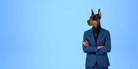 Portrait of confident businessman with dog head standing with crossed arms over blue copy space background. Concept of leadershipの写真素材