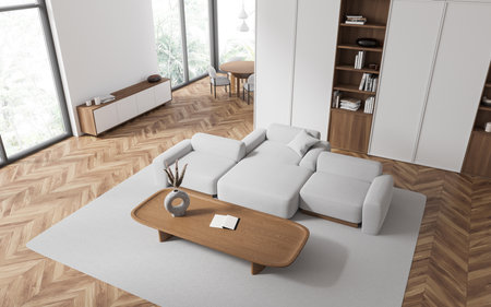 Top view of hotel living room interior with sofa and coffee table, carpet on hardwood floor. Dining...
