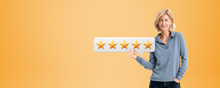 Portrait of happy young European woman holding speech bubble with five star sign standing over...
