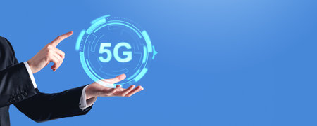 Businessman hand and finger touching 5G icon, wide format on copy space empty blue background....