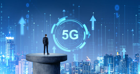 Rear view of young businessman looking at futuristic 5G sign in night city sky. Concept of telecommunication and internet connectionの写真素材