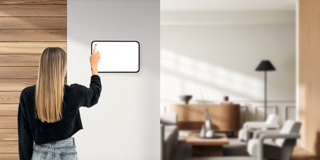 Woman finger touch mockup tablet screen on wall partition, living room interior with lounge zone....