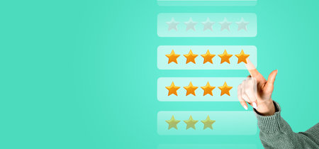 Hand of young woman giving five stars rating over green copy space background. Concept of product...