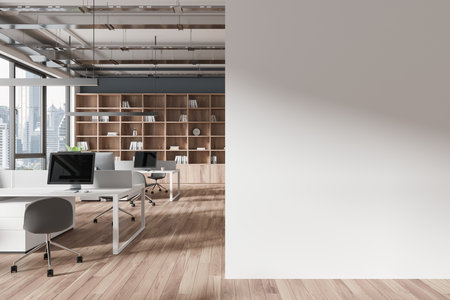 Modern office interior with desks, computers, and city view, featuring a wooden floor and bookshelf, with an empty wall mockup. 3D Renderingの写真素材