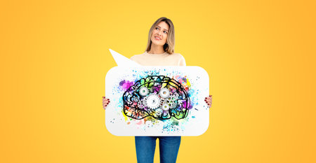 Smart young woman showing thought bubble with colorful brain with gears, orange background. Concept of human mind, art and science, creativity, knowledge and ideaの写真素材