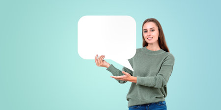 Woman holding blank speech bubble on light blue background, copy space mockup concept