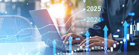 Hands typing on a laptop with overlay of financial graphs and charts, in a modern office setting,...