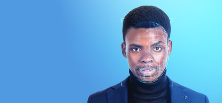 Black businessman portrait and digital biometric scanning hologram, face detection and recognition on empty blue background. Concept of face id and artificial intelligenceの写真素材