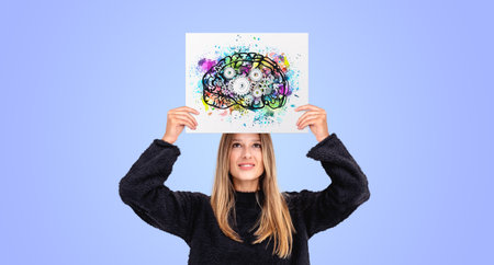 Smart young woman showing poster with colorful brain with gears above head, colored background. Concept of human mind, art and science, creativity, knowledge and ideaの写真素材