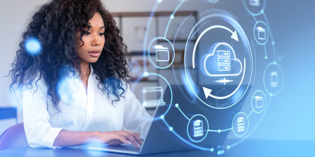 Black woman using laptop, cloud service hologram icons, files share or transfer. Concept of...