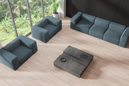 Top view of lounge zone interior with blue sofa and soft armchairs, granite coffee table on hardwood...