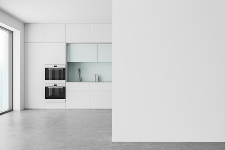 Modern kitchen interior with white cabinets, built-in appliances, and a large blank wall for mockup. Minimalistic design with ample natural light. 3D Rendering.の写真素材