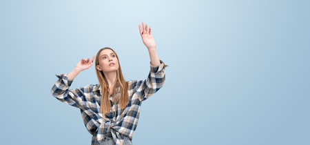 Young woman finger touch something on empty gray background. Hand click or point at virtual screen, wide format. Concept of website, internet and link, virtual realityの写真素材