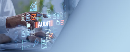 Businessman using laptop and finger touch virtual screen with audit, office documents hologram and check mark. Concept of quality control, data analysis and certification. Copy spaceの写真素材