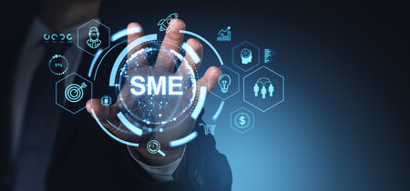 Closeup man hand touch SME glowing hologram, different management and strategy icons. Business growth, start up and technology. Concept of small and medium-sized enterprisesの写真素材