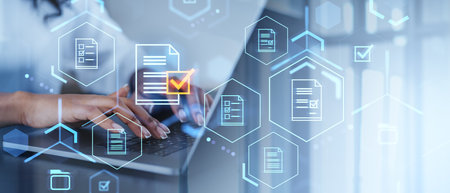 Hands typing on a laptop with holographic icons of documents and checkmarks. Blurred background. Concept of data security and digital accessの写真素材