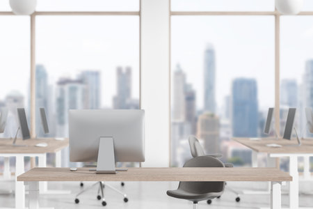 Work desk with pc computer, blurred background of coworking interior with armchairs and panoramic window. Mockup for business product display or promotion. 3D renderingの写真素材