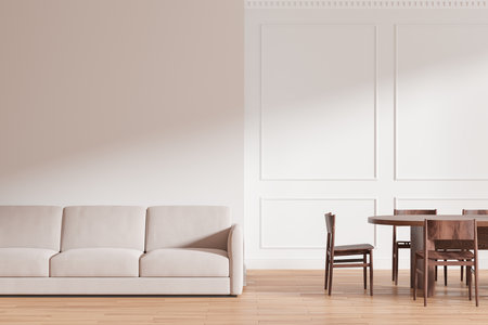 Modern living room with beige sofa and wooden dining set against a white wall. Minimalist design on...