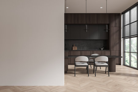 Empty wall with a modern kitchen in the background. Dining table with chairs, wooden floor, large windows. Home decor concept. 3D Renderingの写真素材