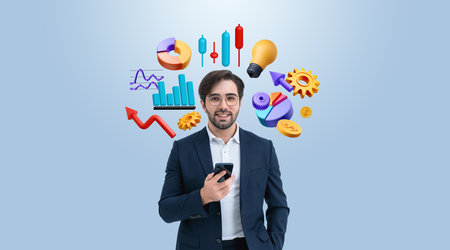A man in a business suit holding a smartphone, surrounded by floating business icons on a light blue background. Startup and success conceptの写真素材
