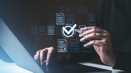 Hands interacting with digital documents and a checkmark icon on a dark background, symbolizing online approval and verificationの写真素材