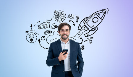 Businessman with beard and eyeglasses using phone. Happy portrait with doodle sketch start up plan on colored wall, graphs and rocket launch. Concept of future opportunities, project and leadershipの写真素材
