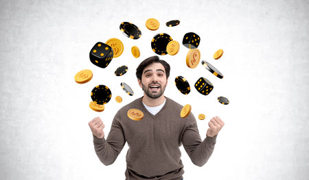 Man with excited expression surrounded by floating casino chips and dice against a white background, symbolizing luck and fortuneの写真素材