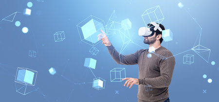 Man working in virtual reality glasses, finger touch information fields hologram and blocks. Concept of metaverse, digital world, augmented reality and integrationの写真素材