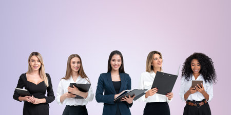 Multiracial businesswomen with gadget and clipboard, portraits in row on empty copy space background. Concept of conference, teamwork and communicationの写真素材