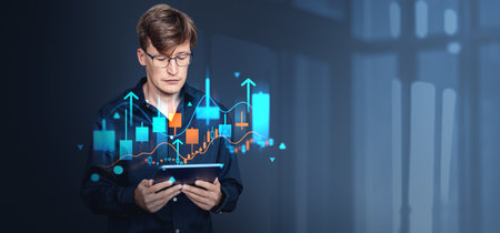 Businessman in eyeglasses working in tablet, stock market candlesticks and arrows rising, forex graph analysis and copy space background. Concept of online trading and investmentの写真素材
