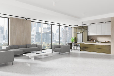 Corner view of flat studio interior with sofa on concrete floor. Cooking and eating space with bar island, cabinet with kitchenware. Panoramic window on Bangkok skyscrapers. 3D renderingの写真素材