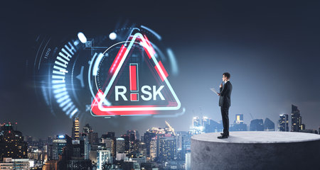 Businessman analyzing risk icon over a city skyline. Futuristic digital graphics. Concept of risk management and strategic planningの写真素材