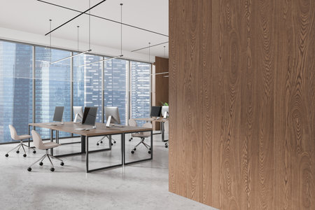 Office interior with wooden walls and desks, featuring computers and chairs. Large city view windows. Concept of modern workspace. 3D Renderingの写真素材