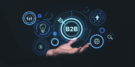 Man hand closeup holding b2b glowing hologram hud icons with gears, business goal, arrow and global teamwork. Concept of financial marketing, startup and business to businessの写真素材