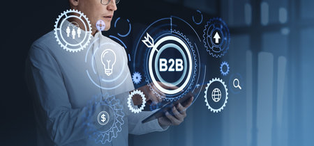 Businessman finger touch tablet, b2b glowing hologram icons and gears. Financial marketing and target audience search, analysis. Concept of business to business and e-commerceの写真素材