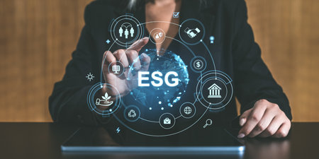Businessperson interacts with digital ESG interface, highlighting global sustainability. Modern graphic style on blurred backgroundの写真素材