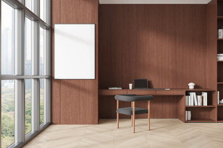 Office interior featuring a blank poster on a wooden wall, with desk and chair. Natural light from large windows. Concept of workspace. 3D Renderingの写真素材