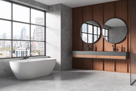 Spacious, modern bathroom interior with large windows, a freestanding tub, and double round mirrors on a wooden wall. 3D Renderingの写真素材