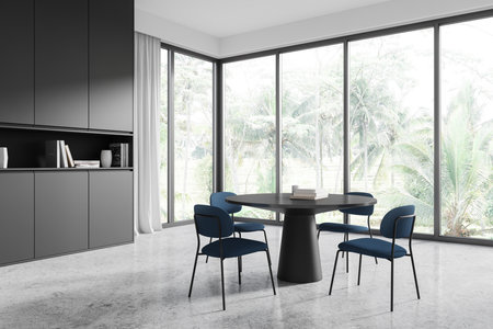 Elegant dining room with black table, blue chairs, and large windows overlooking greenery. Minimalist modern design in a bright space. 3D Renderingの写真素材