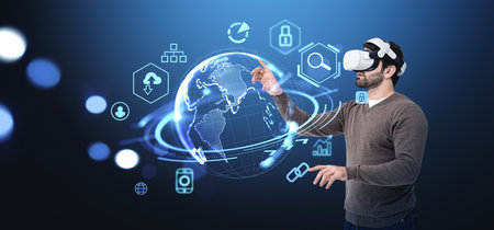 Young man in vr glasses finger touch earth sphere hologram, digital web icons hud. Concept of global connection, network in metaverse, augmented reality and integrationの写真素材